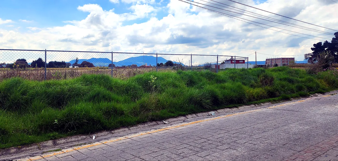 Frente del predio sobre la calle adoquinada, con los cerros al fondo